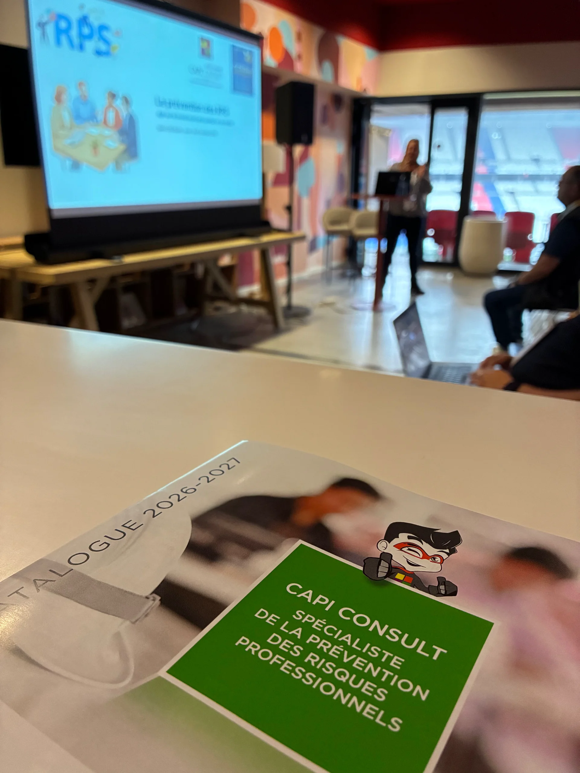 Support imprimé posé sur une table pendant une présentation dans une salle de réunion.