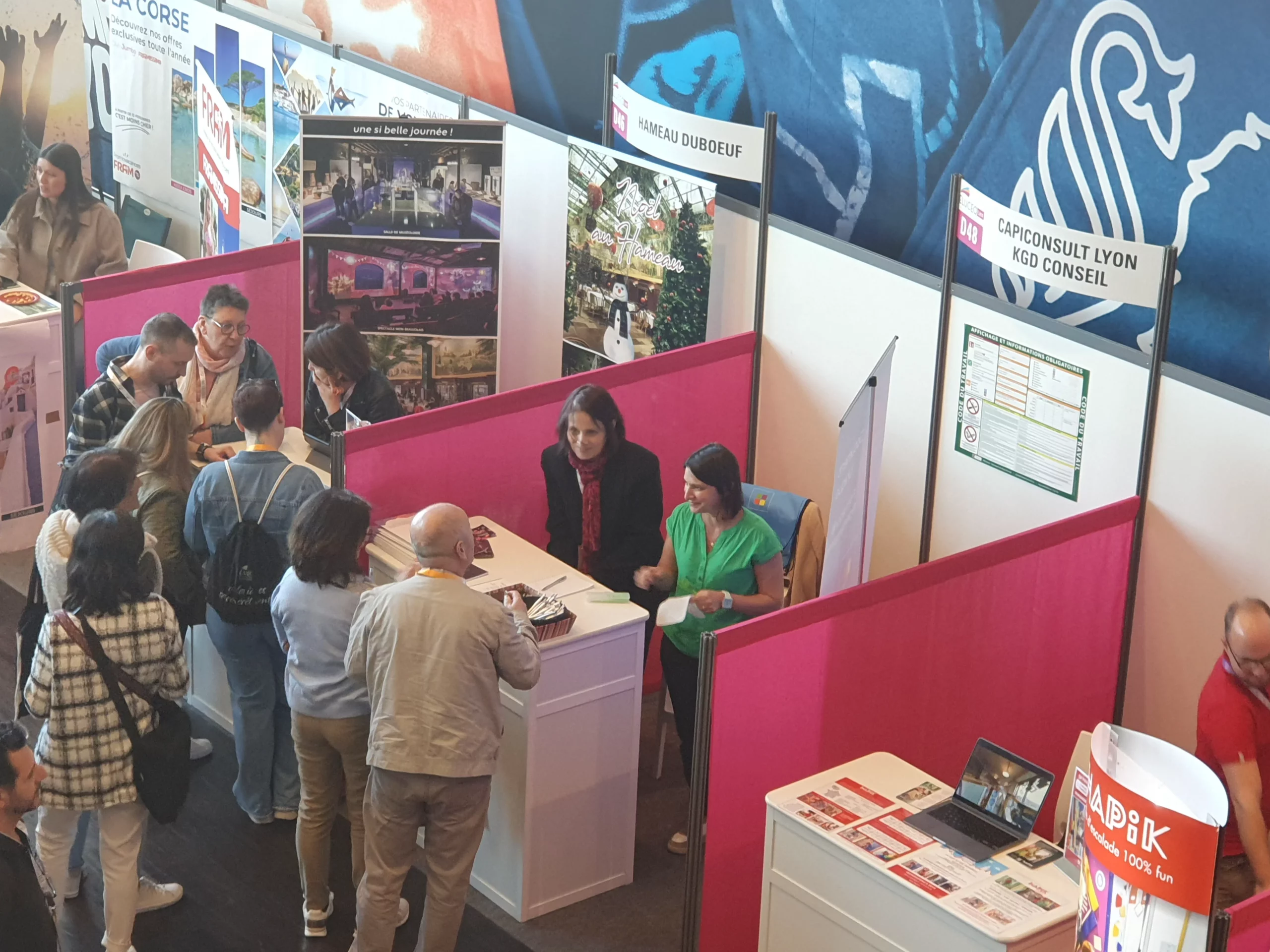 Visiteurs et stands d’information dans un espace d’exposition professionnel